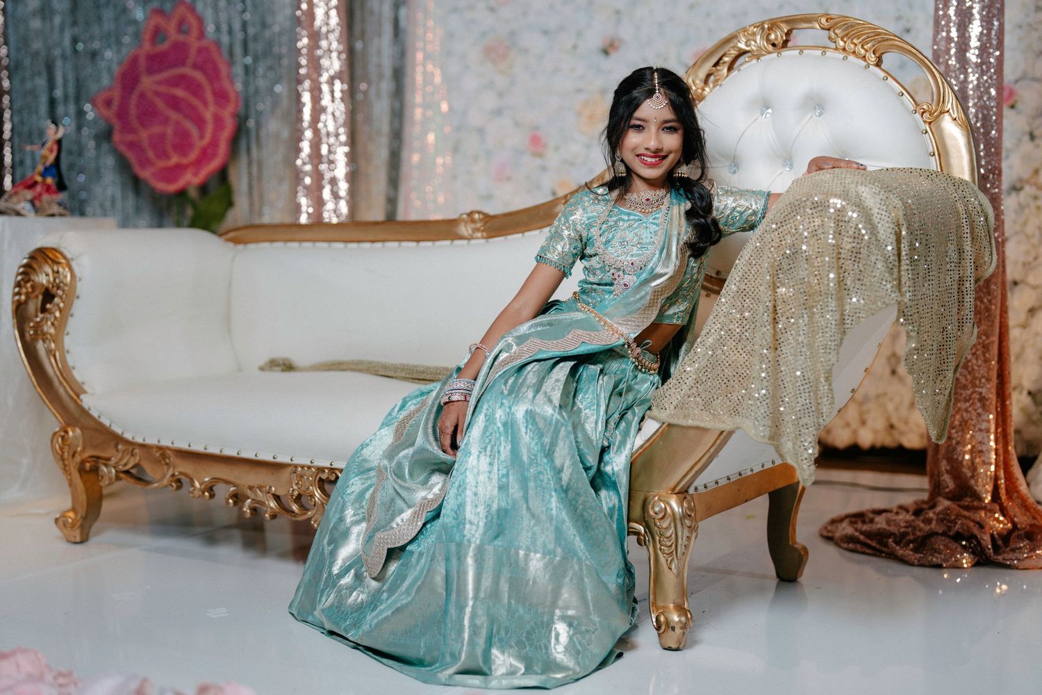 Elegant ornate gold chairs with turquoise cushions arranged in a formal setting against a light backdrop.