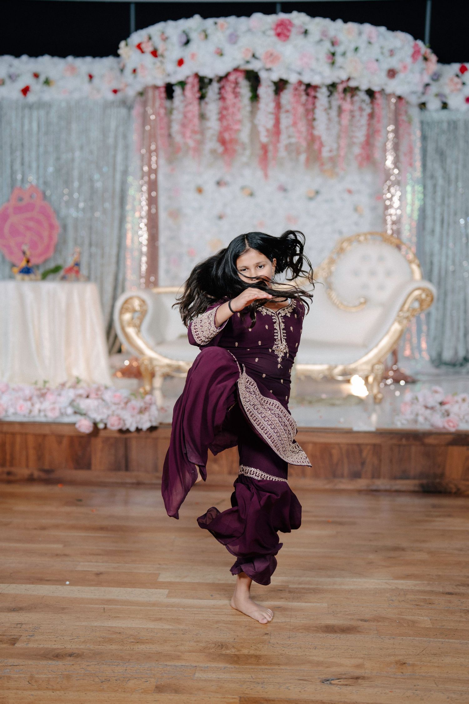 A sequence of dance movements showing a twirling figure in a purple dress against a floral backdrop.