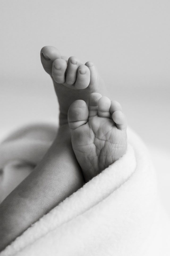 Vastasyntynyt vauva nukkuu rauhallisesti vaaleassa kapalossa, newborn kuvaus Jyväskylä, Muurame, yksityiskohta varpaista