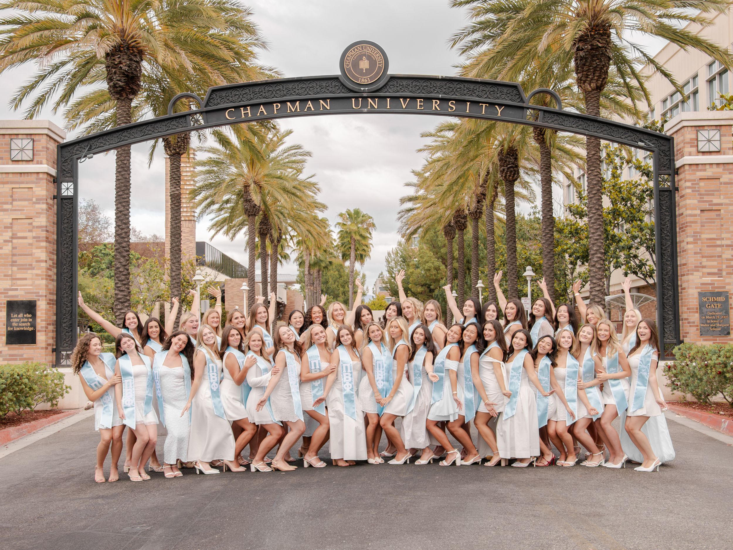 Chapman University Pi Beta Phi Class of '26 pose together under their campus entrance arch.