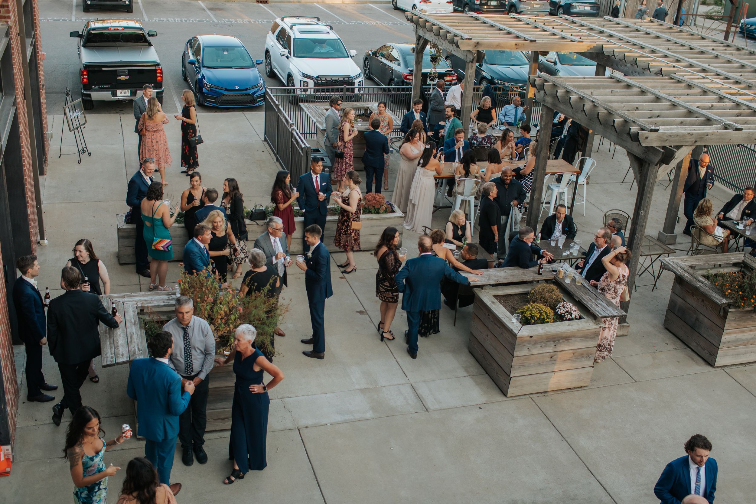 Aerial view of people gathering at an urban outdoor plaza with modern architecture and seating.
