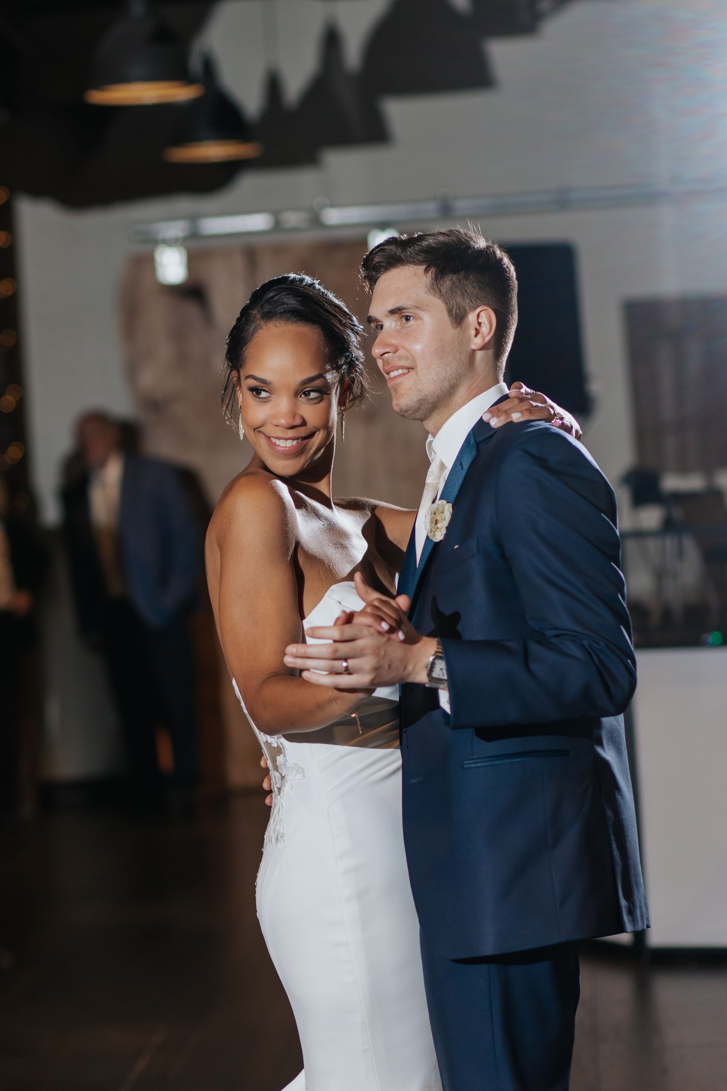 Couple dancing together in formal attire at their wedding reception.