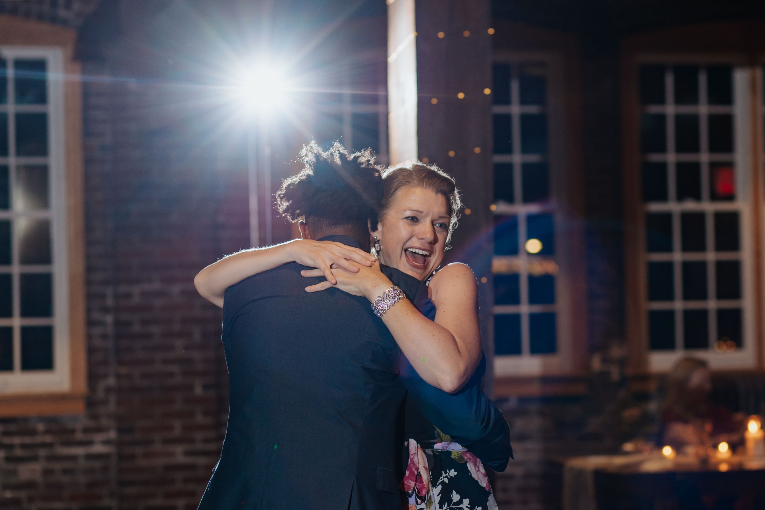 A couple dances together in an intimate moment on an illuminated dance floor at night.