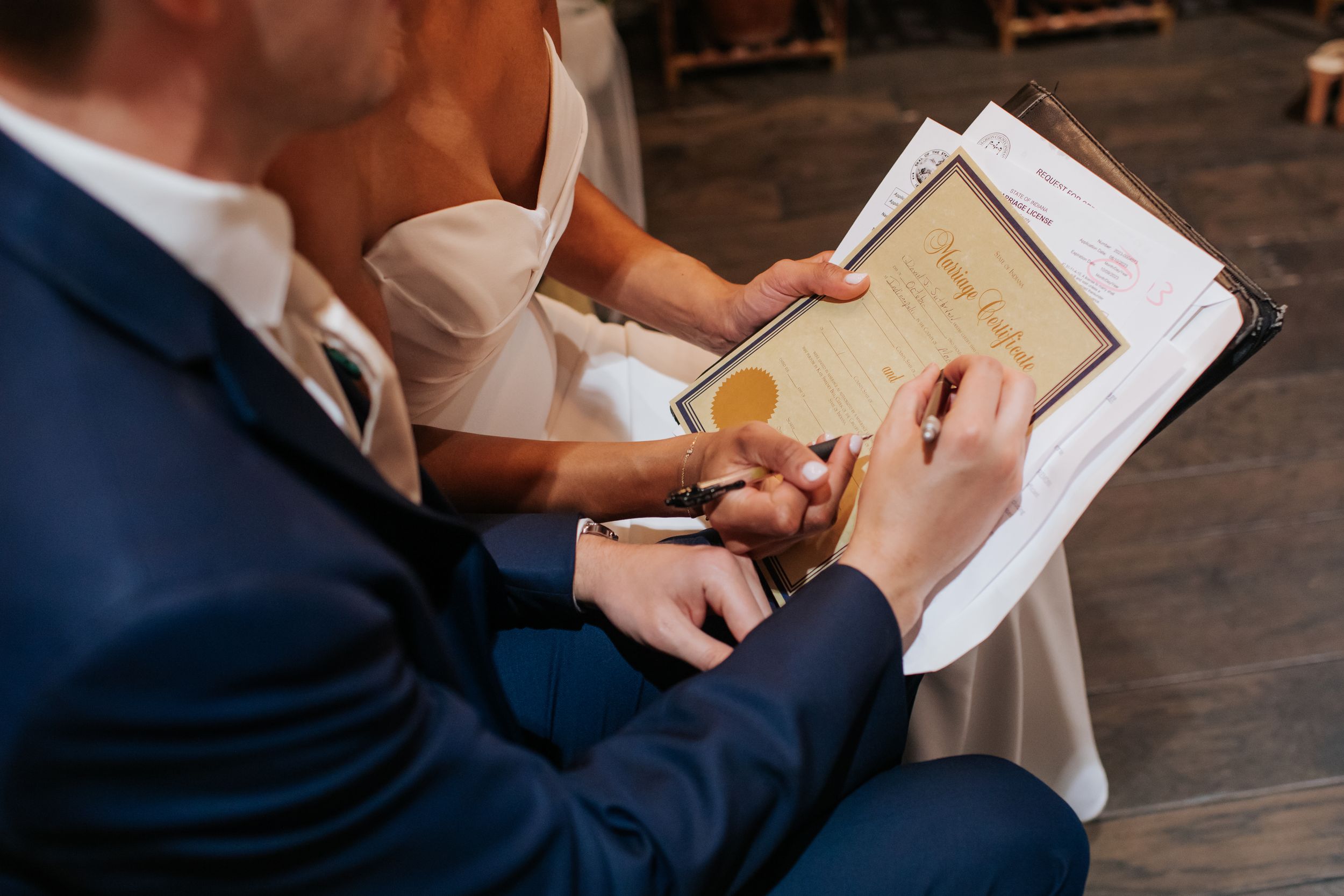 Close-up shot of hands holding and reading from paper documents during a wedding ceremony.