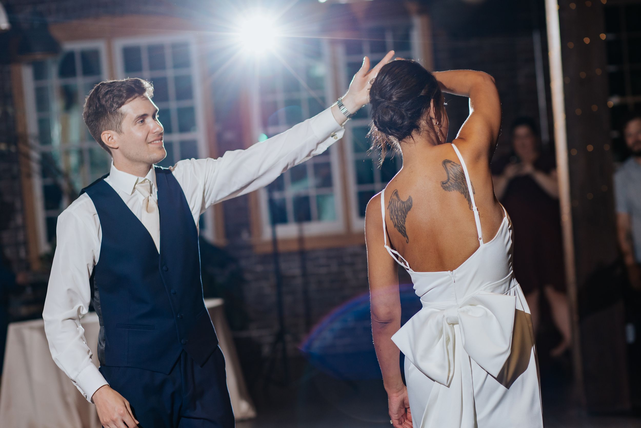 Wedding celebration with dancing and festive lighting in an industrial-style venue.