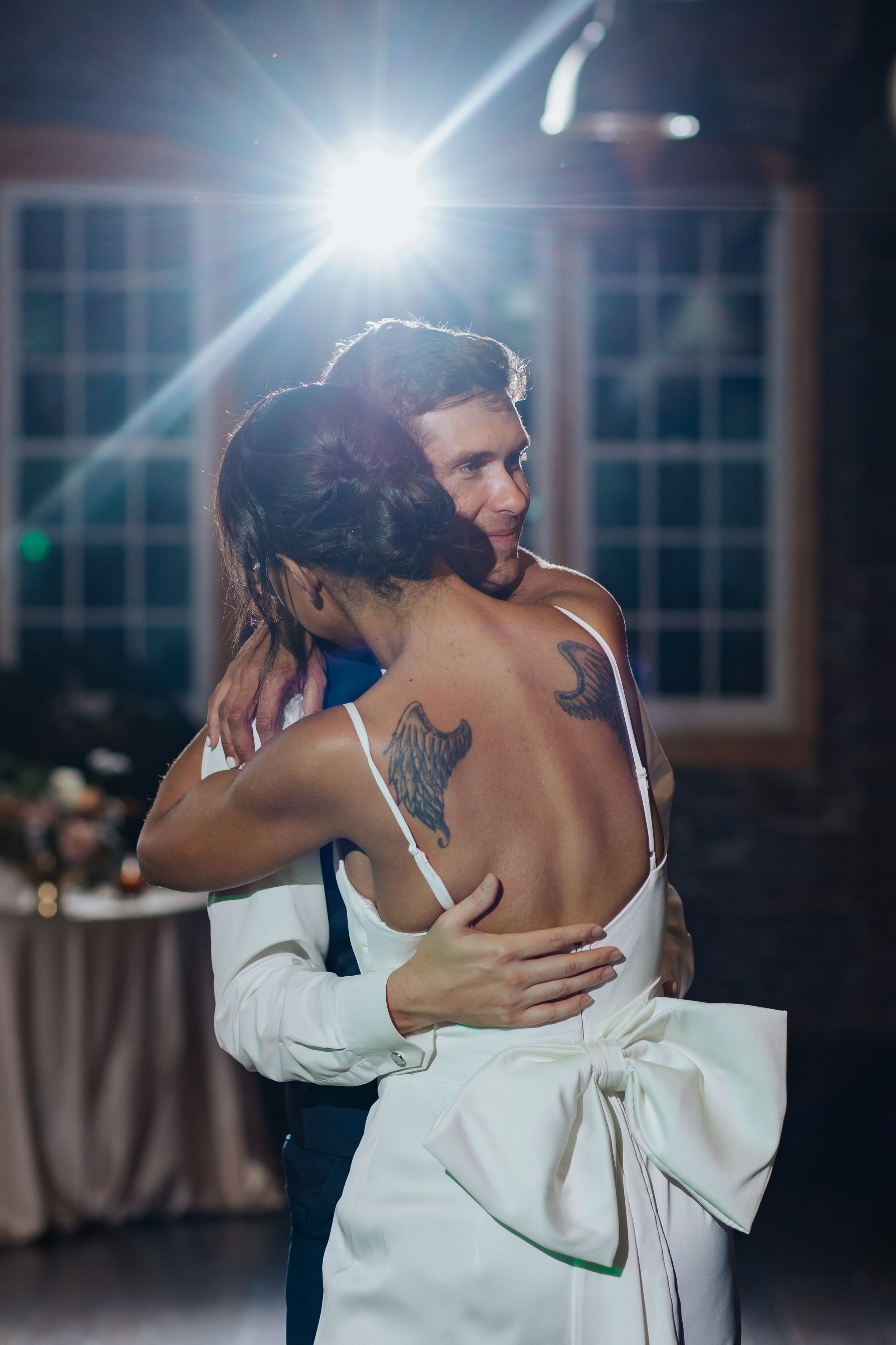 Intimate dance moment captured in a moody venue with dramatic lighting and exposed brick walls.
