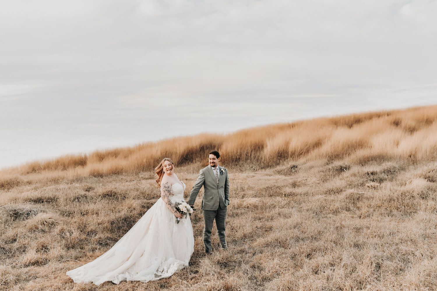 Editorial wedding portrait of couple at sunset with dramatic sky and soft winter light