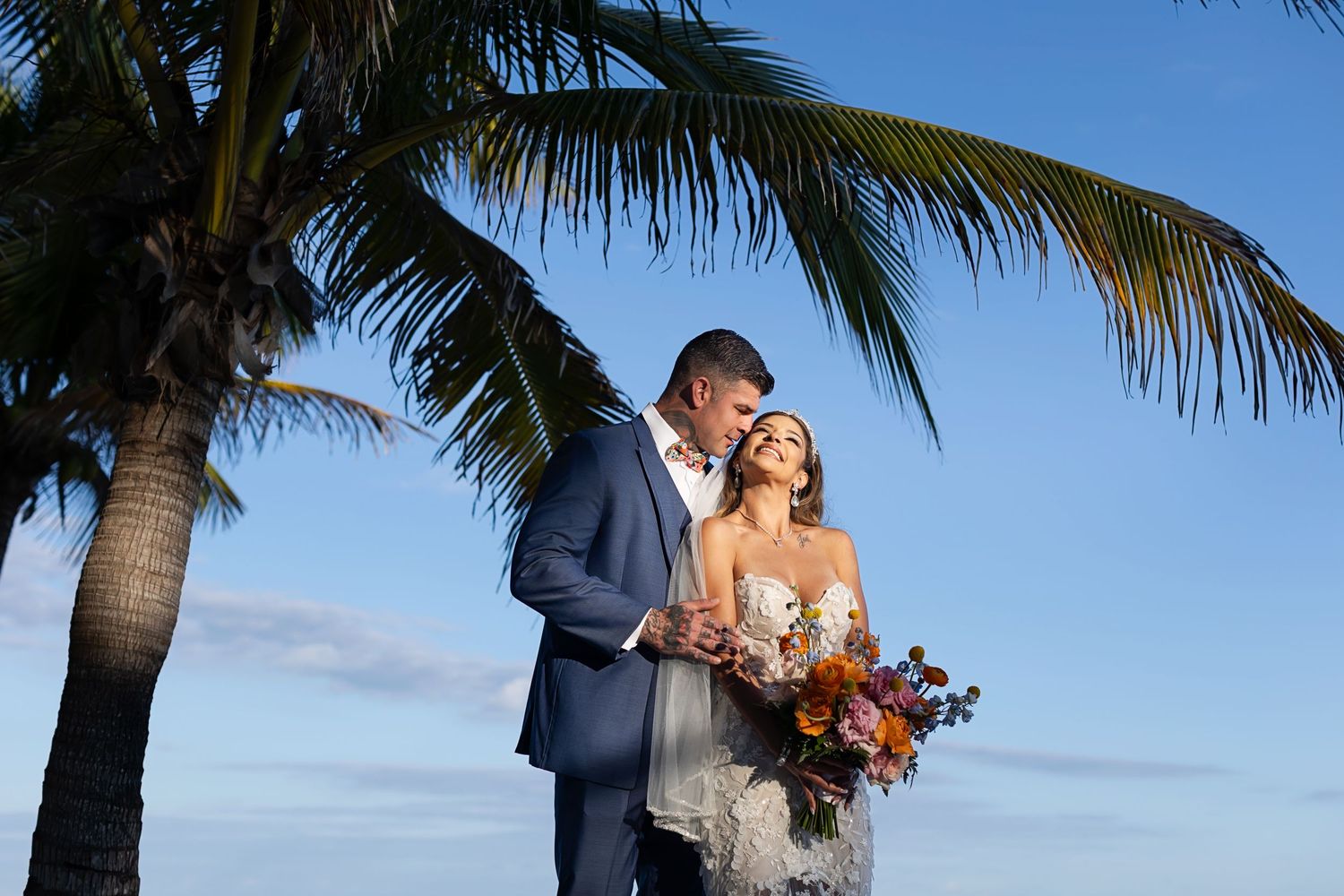Romantic couple portrait under palm trees at Generations Riviera Maya, destination wedding in Mexico.