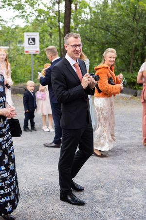 Bryllupsgjest med kamera i hånda. Han oppdaget denne fotografen og smiler.