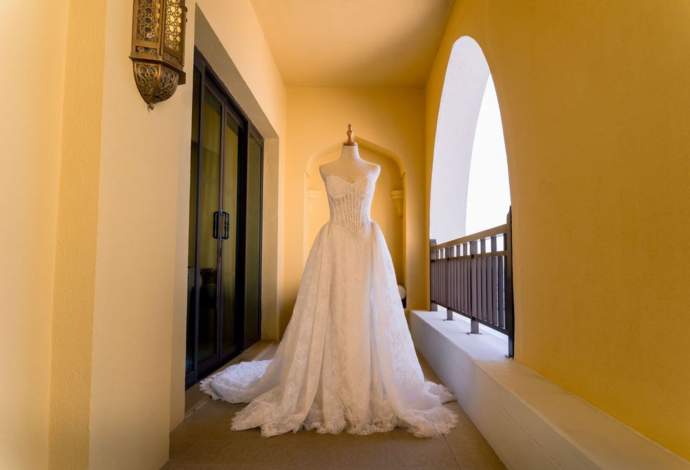 Wedding dresses displayed in a bright yellow hallway with natural lighting streaming through windows.