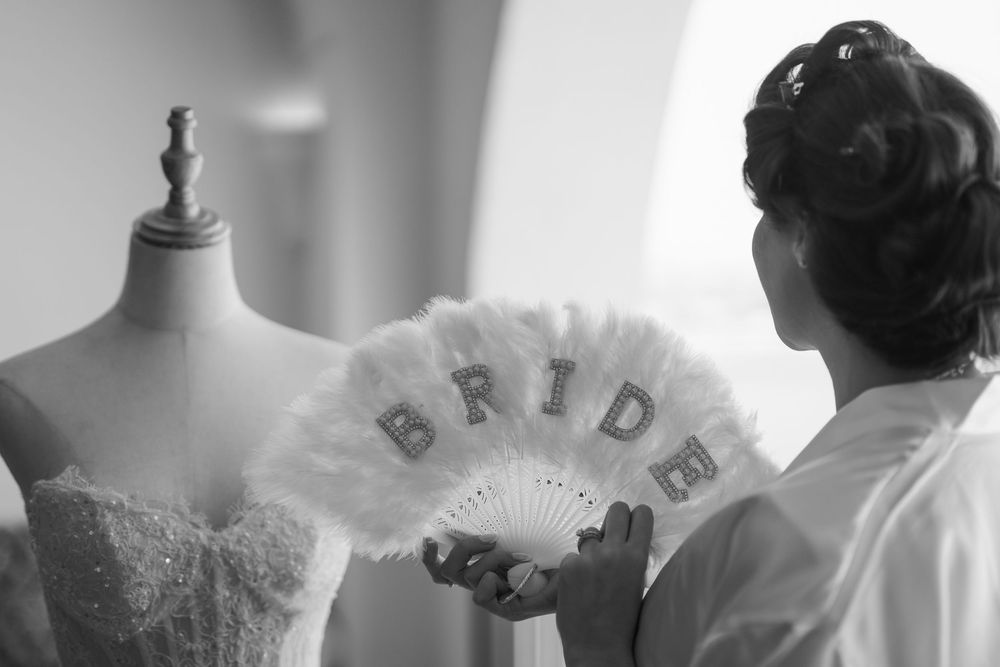 A collection of black and white photos showing wedding dress details and bridal preparations.
