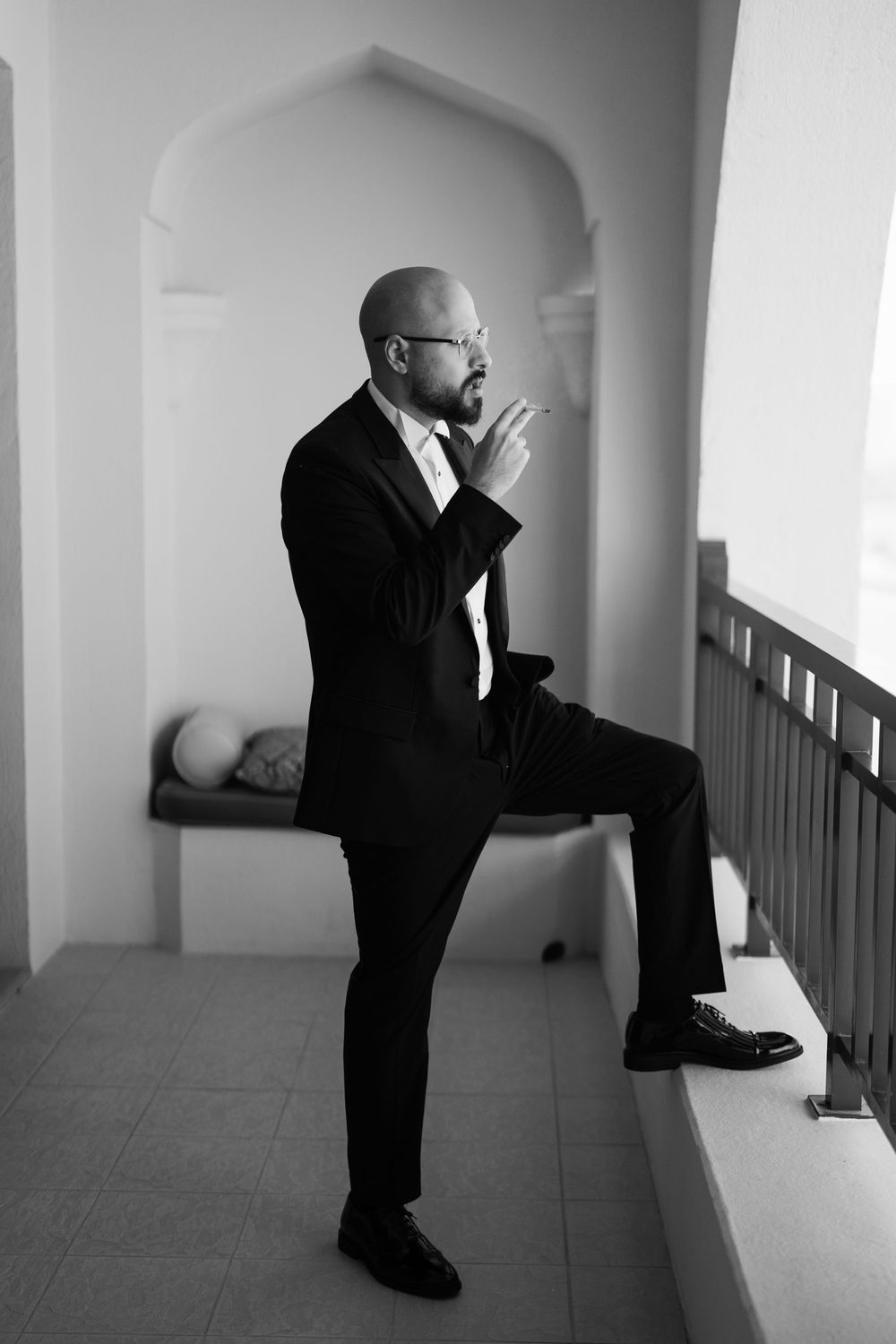 A series of black and white photos showing a person in a suit leaning against a wall in different contemplative poses.
