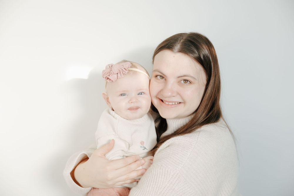 A parent holds a smiling baby in a series of four heartwarming photos against a light background.