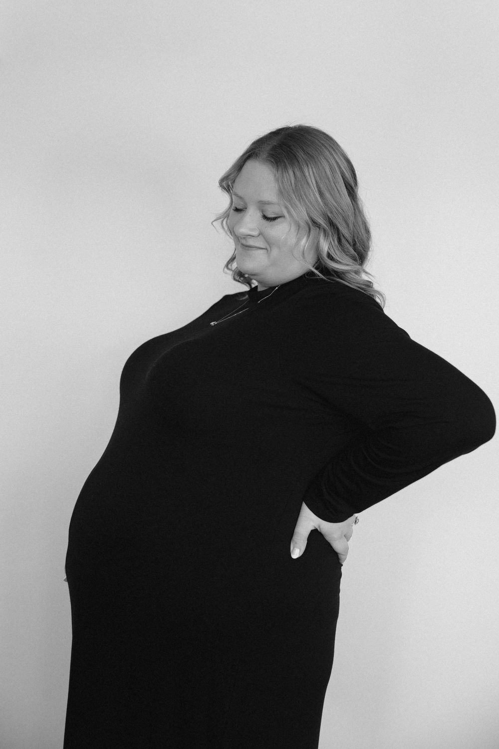 A series of black and white artistic portraits showing a person in a black top against a white background from different angles.