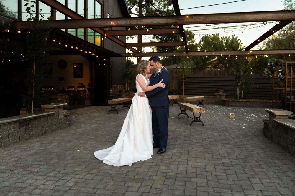 Couple shares romantic moments on an outdoor patio during their wedding celebration.