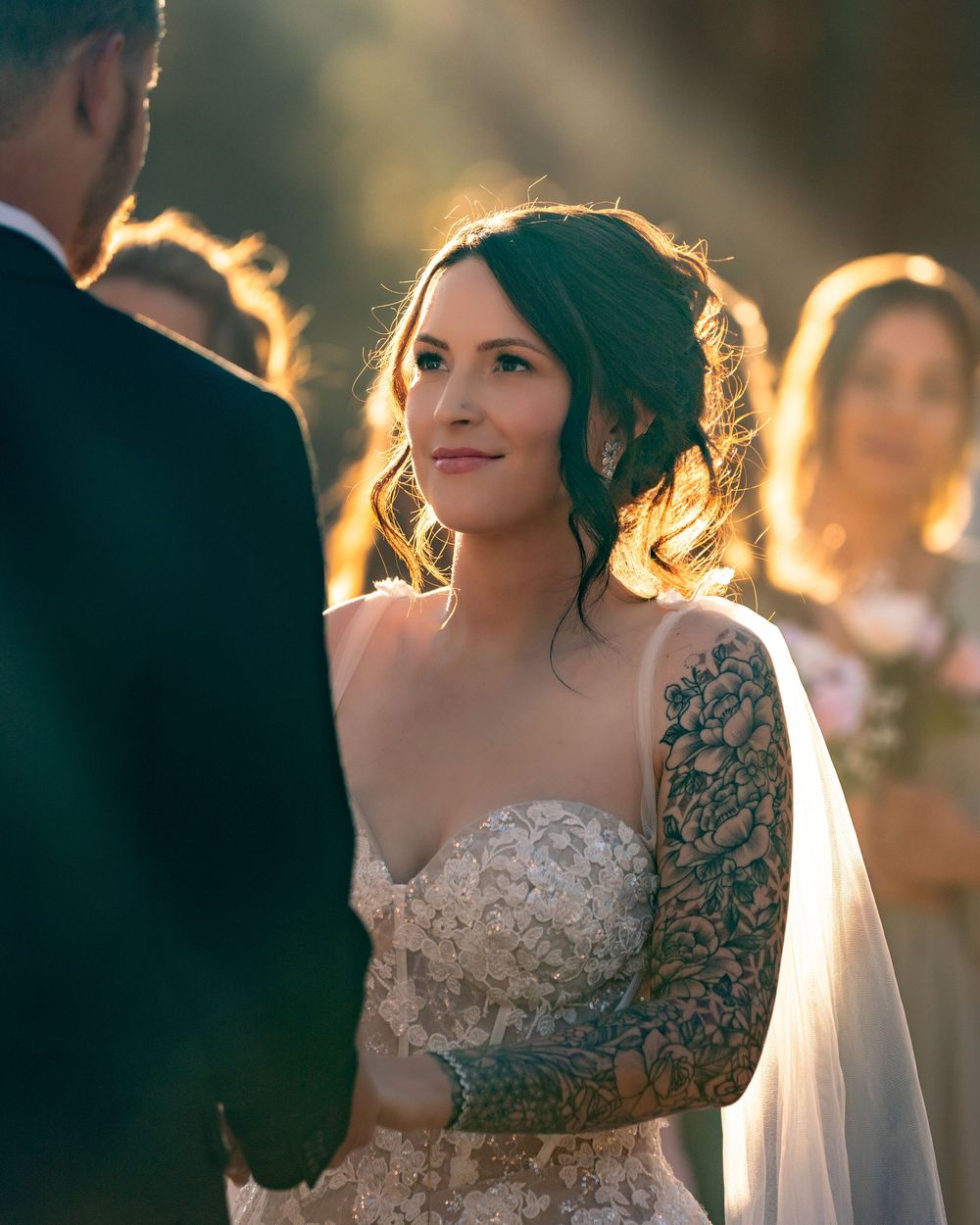 Elegant lace wedding dress details captured in warm sunset lighting.