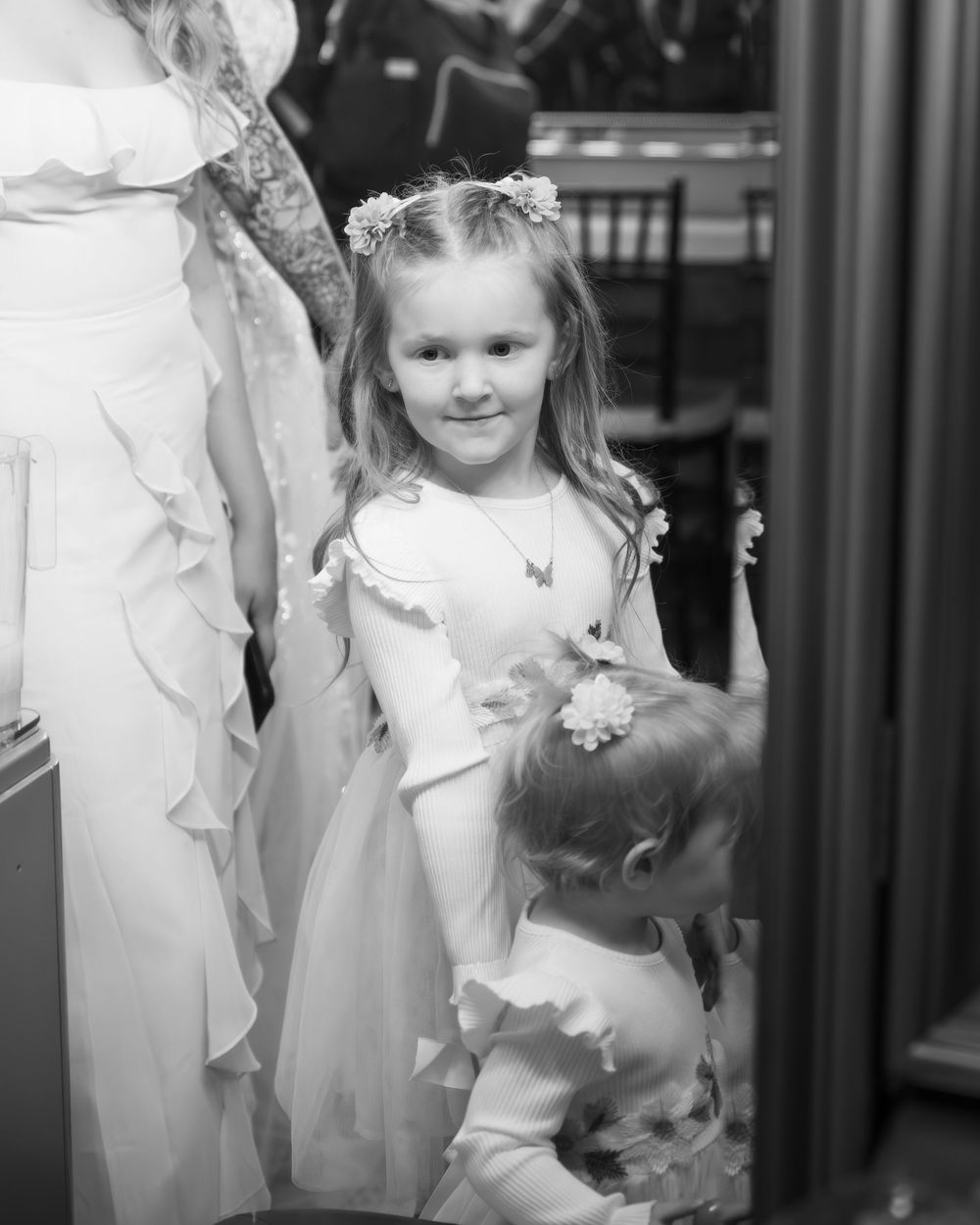 Children in white dresses playing together in an elegant indoor setting.