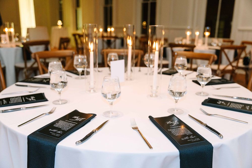 Elegant table settings with white linens and wine glasses in an upscale restaurant dining room.