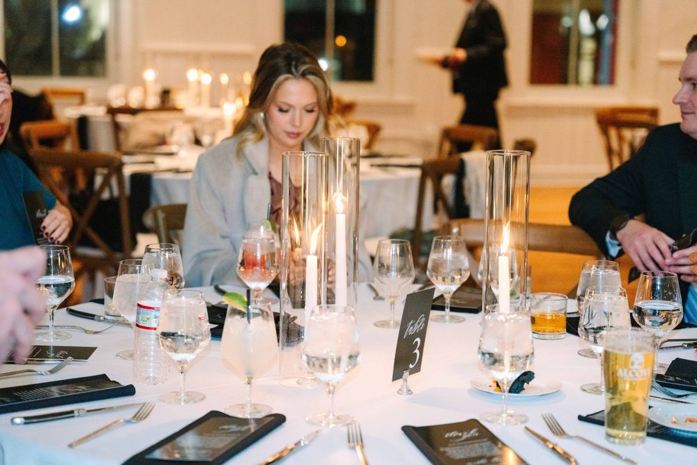 A formal dining table set with candles and glassware for an elegant evening gathering at a restaurant.