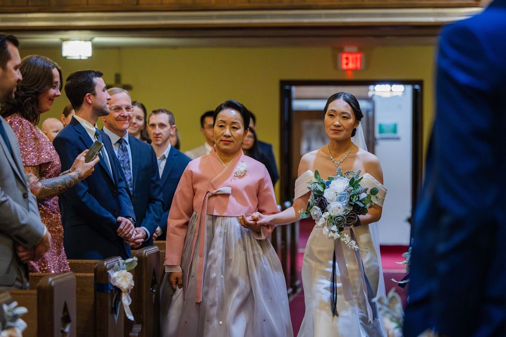 Bride and her mother walk down the aisle to the front of the church