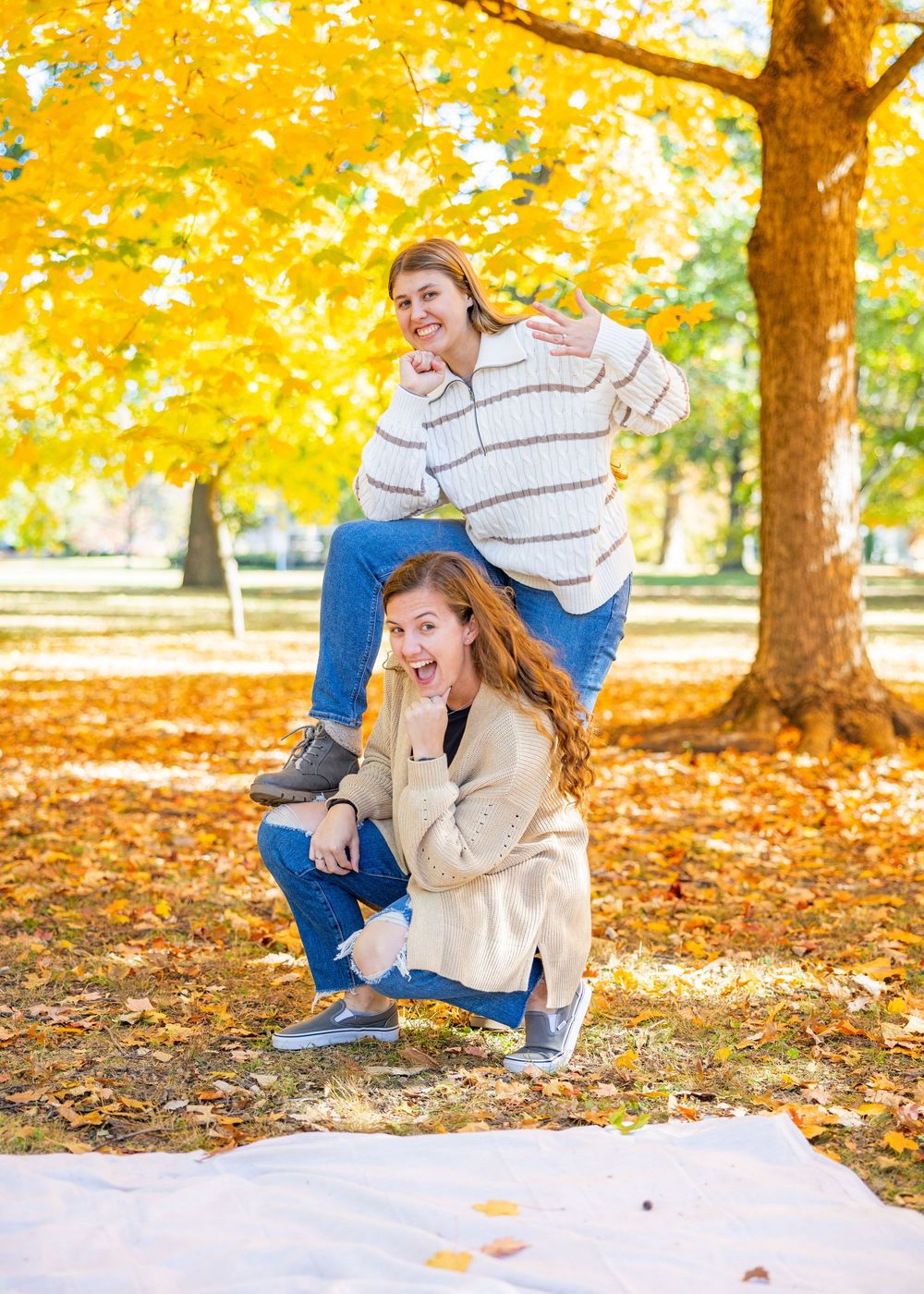 Fiancee and her sister doing a fun pose in the fall