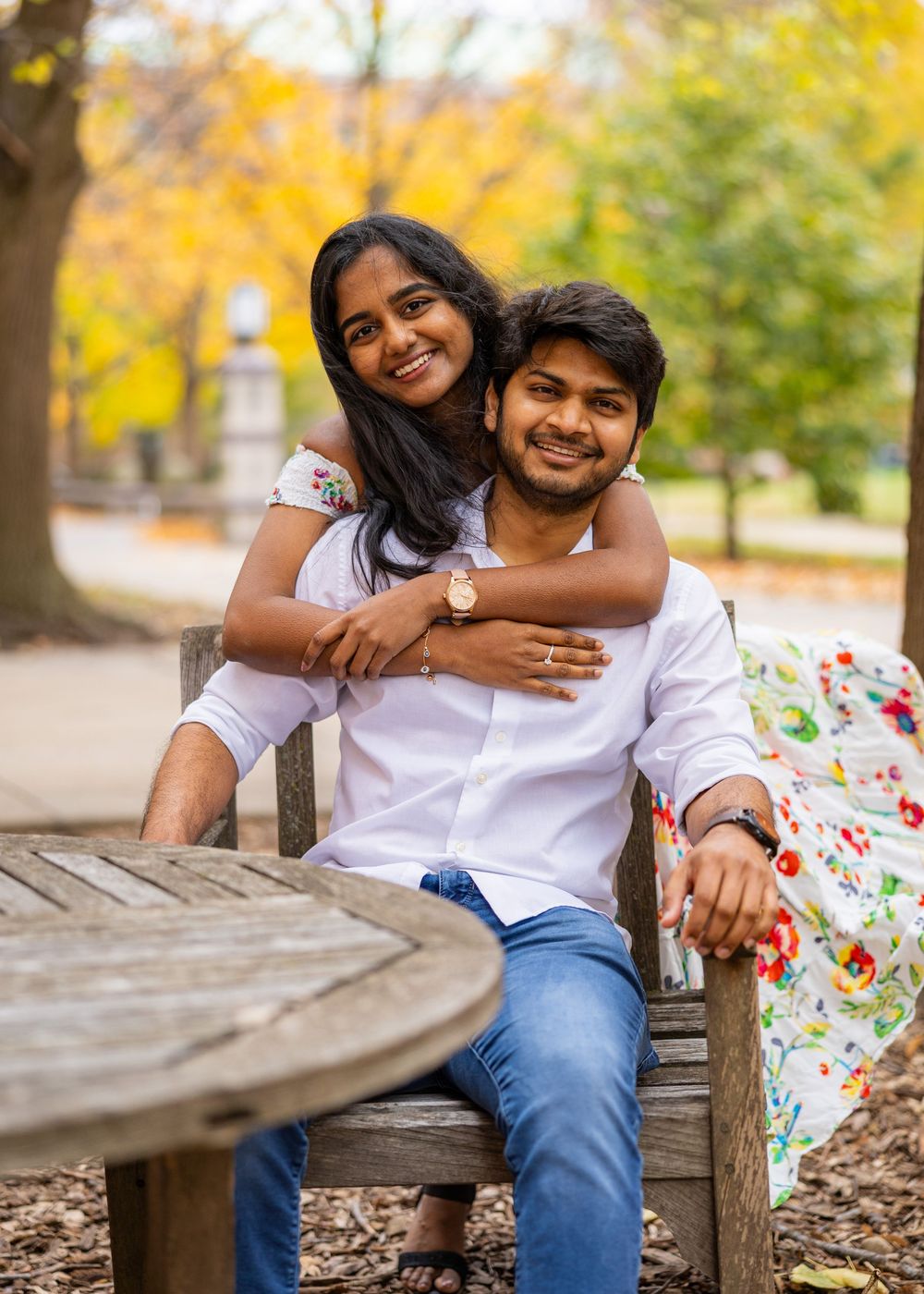 couple at UIUC posing for a photo in front of fall leaves