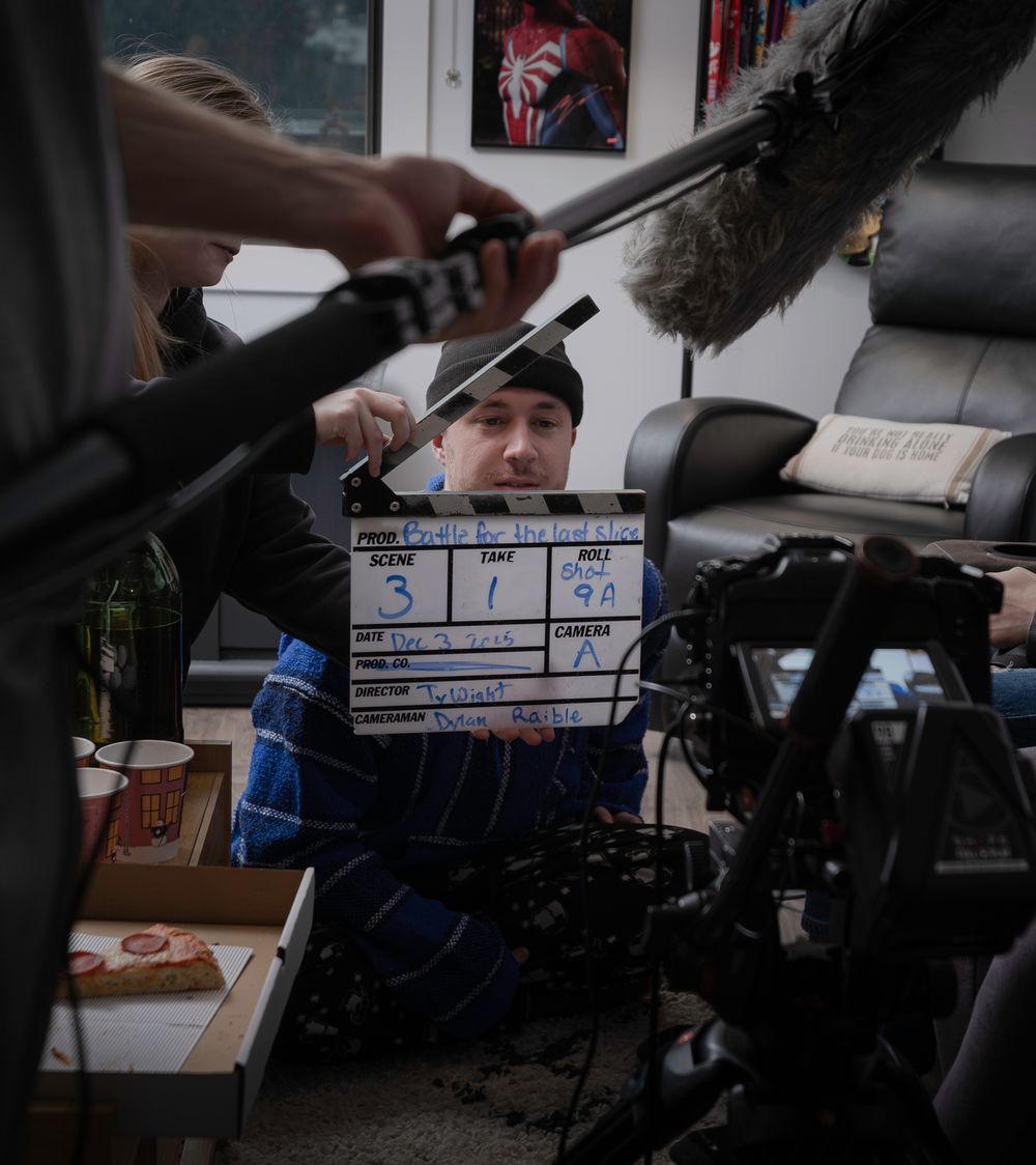 Film crew member holding a clapperboard during video production setup.