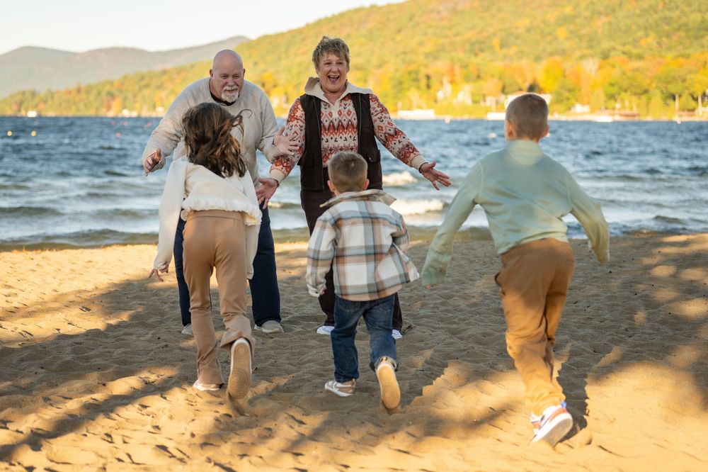 Family walking together on a scenic beach at sunset with golden light filtering through trees.