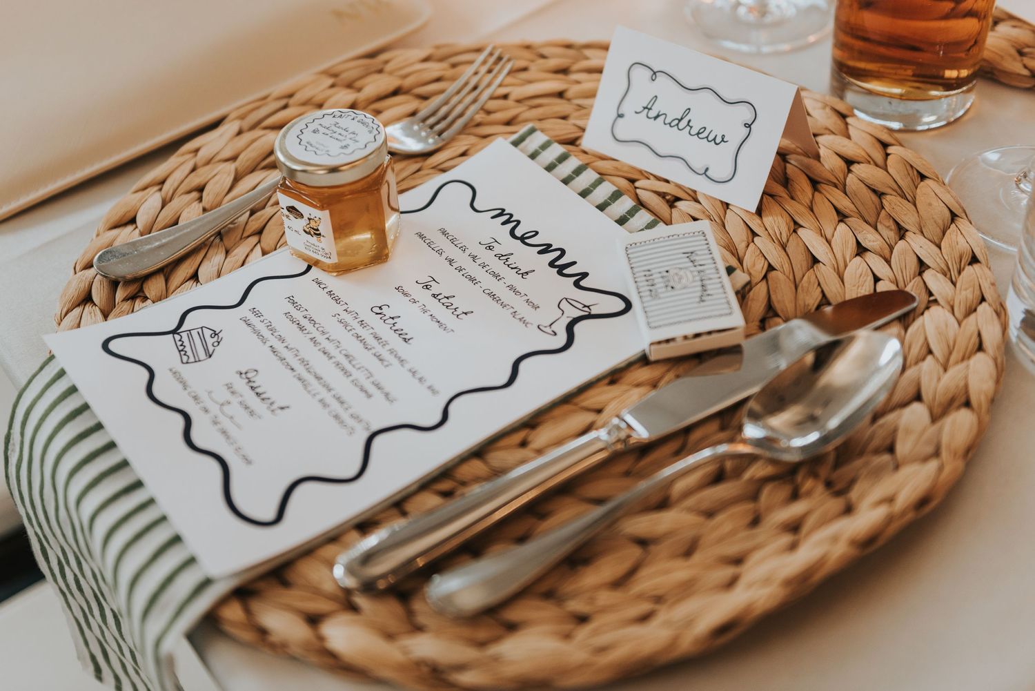 Rustic place settings with menu cards and bone-shaped name tags arranged on woven charger plates.