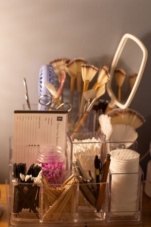 Collection of makeup brushes and beauty tools arranged in clear organizers on a counter.