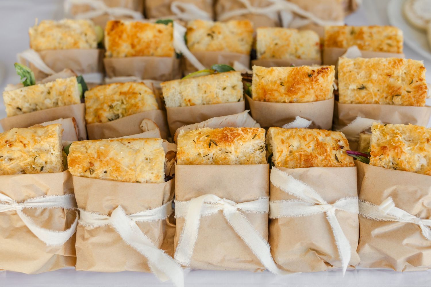 Freshly baked sandwiches  arranged in neat rows on a white serving platter captured by Chelsee Rawe Photography in the Bay Area