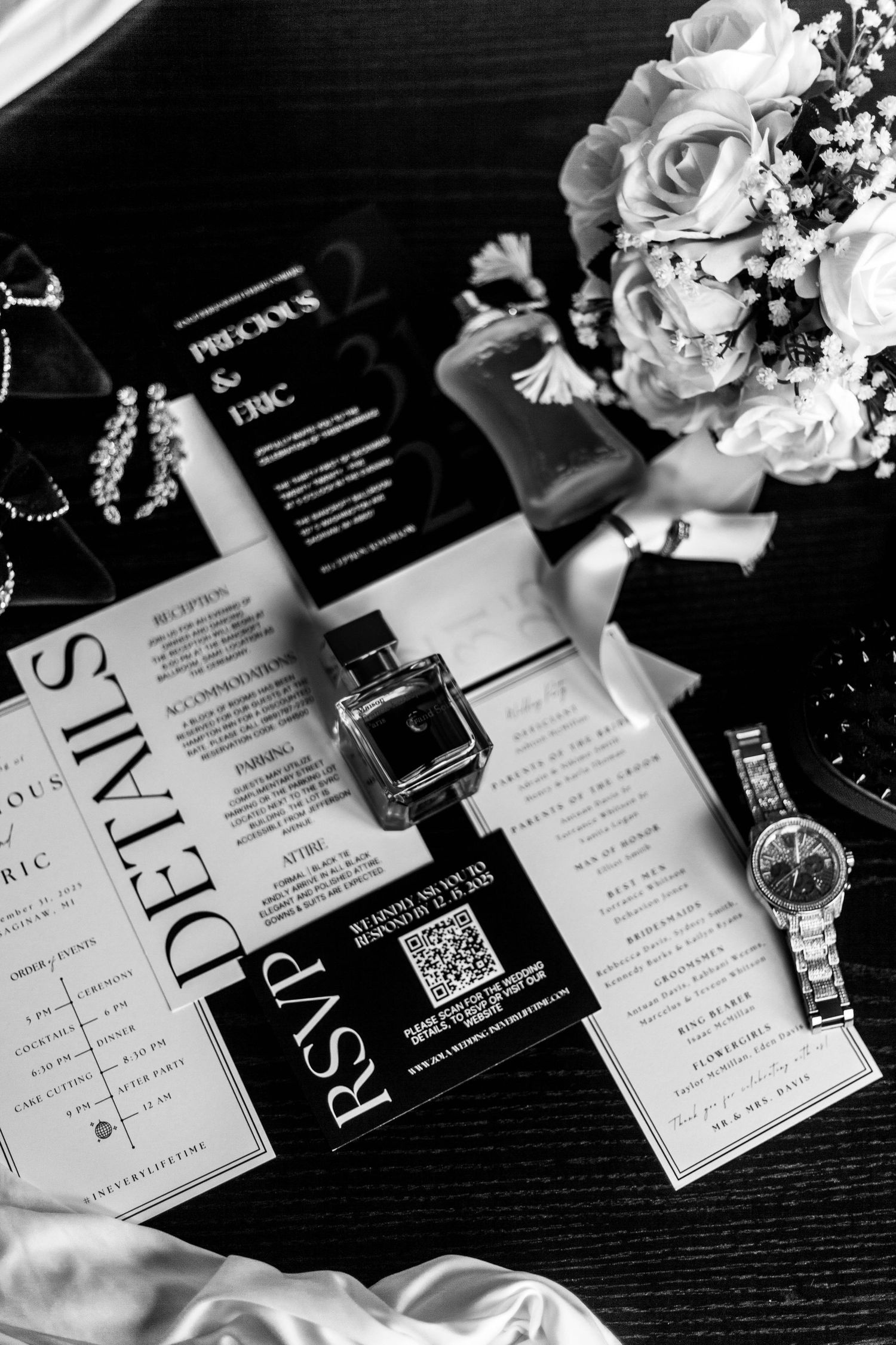 Black and white wedding invitation cards arranged on a dark surface with decorative details visible.