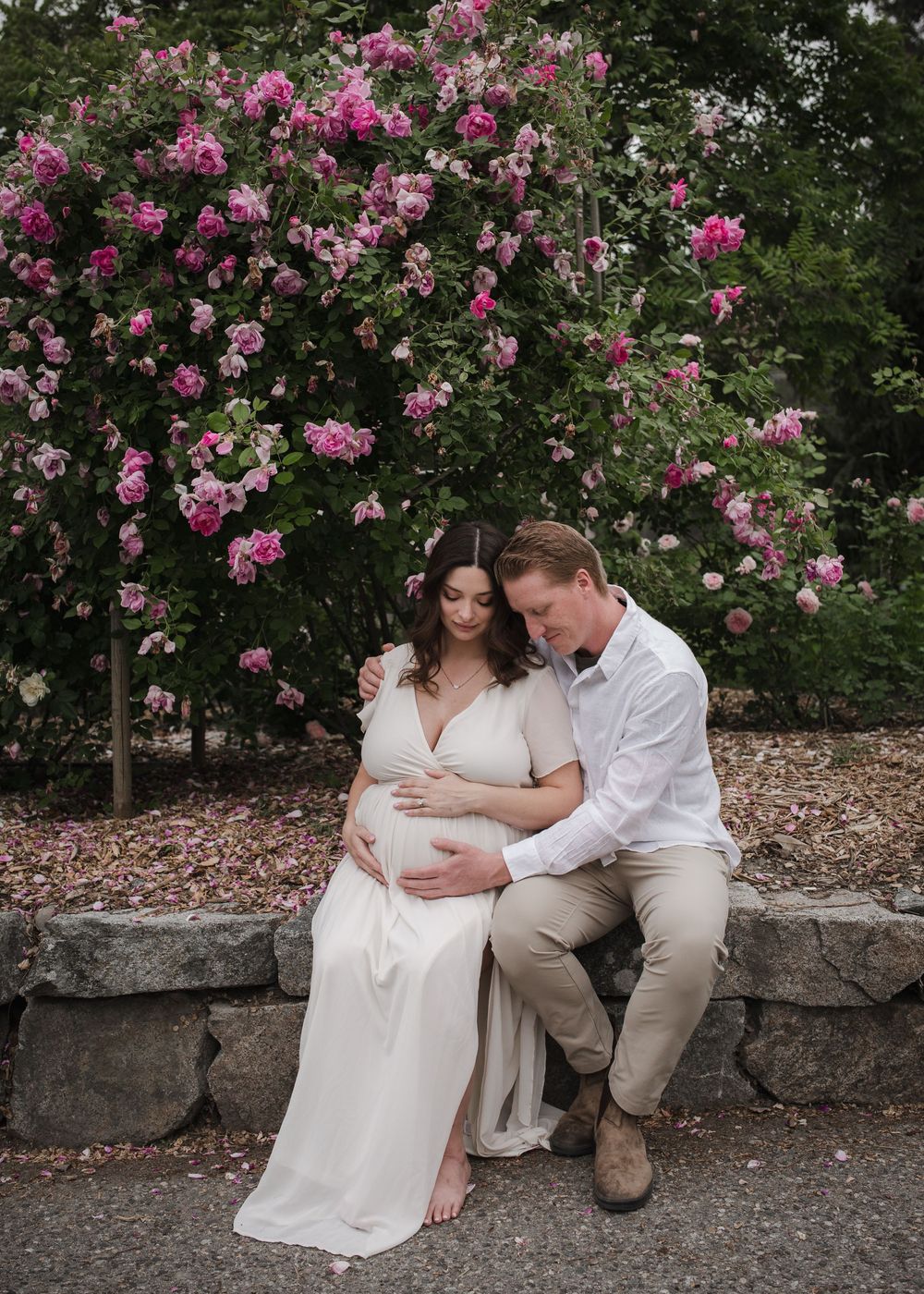 Artistic maternity portrait featuring an expectant mother with flowing hair in a South Okanagan in the roses bushes.