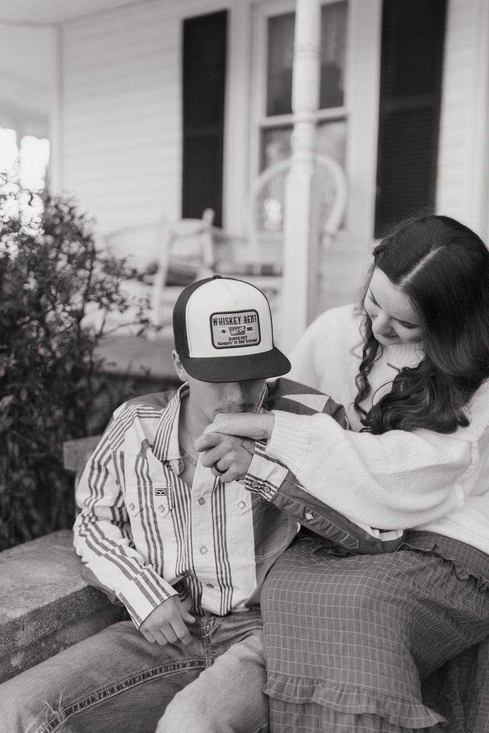 Romantic black and white photo series of a couple sharing tender moments on a porch.