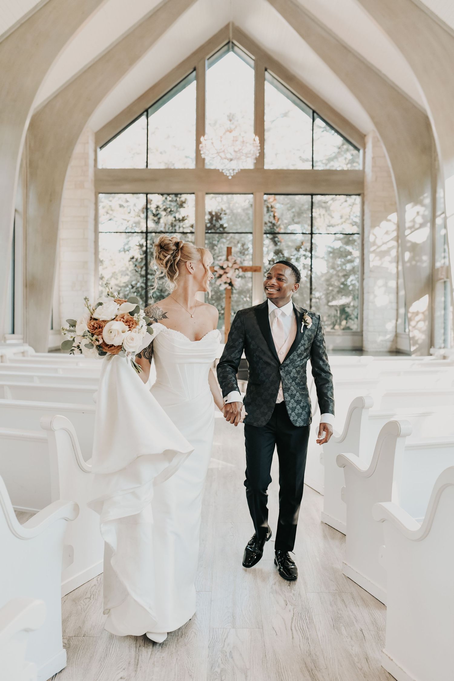 bride and groom smile as they walk down the aisle at brighton abbey