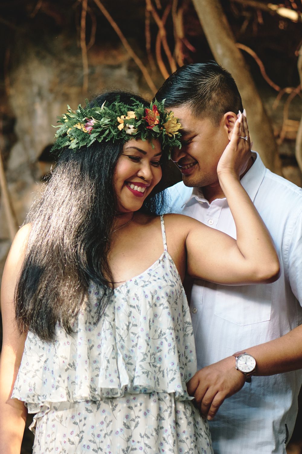 A couple shares playful moments together against a natural backdrop.