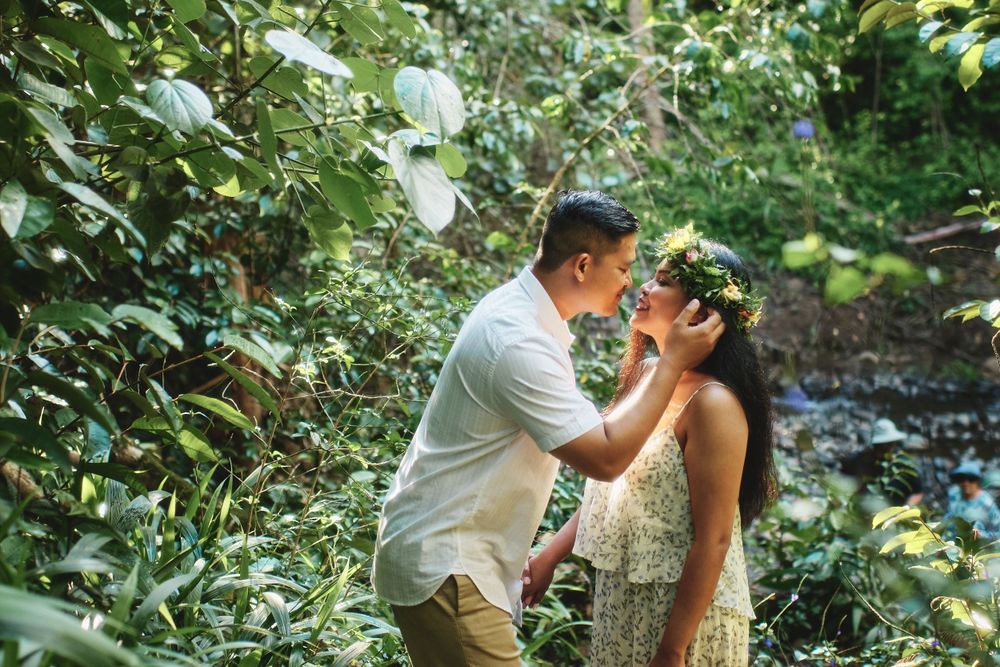 A couple embraces in a lush tropical garden setting.