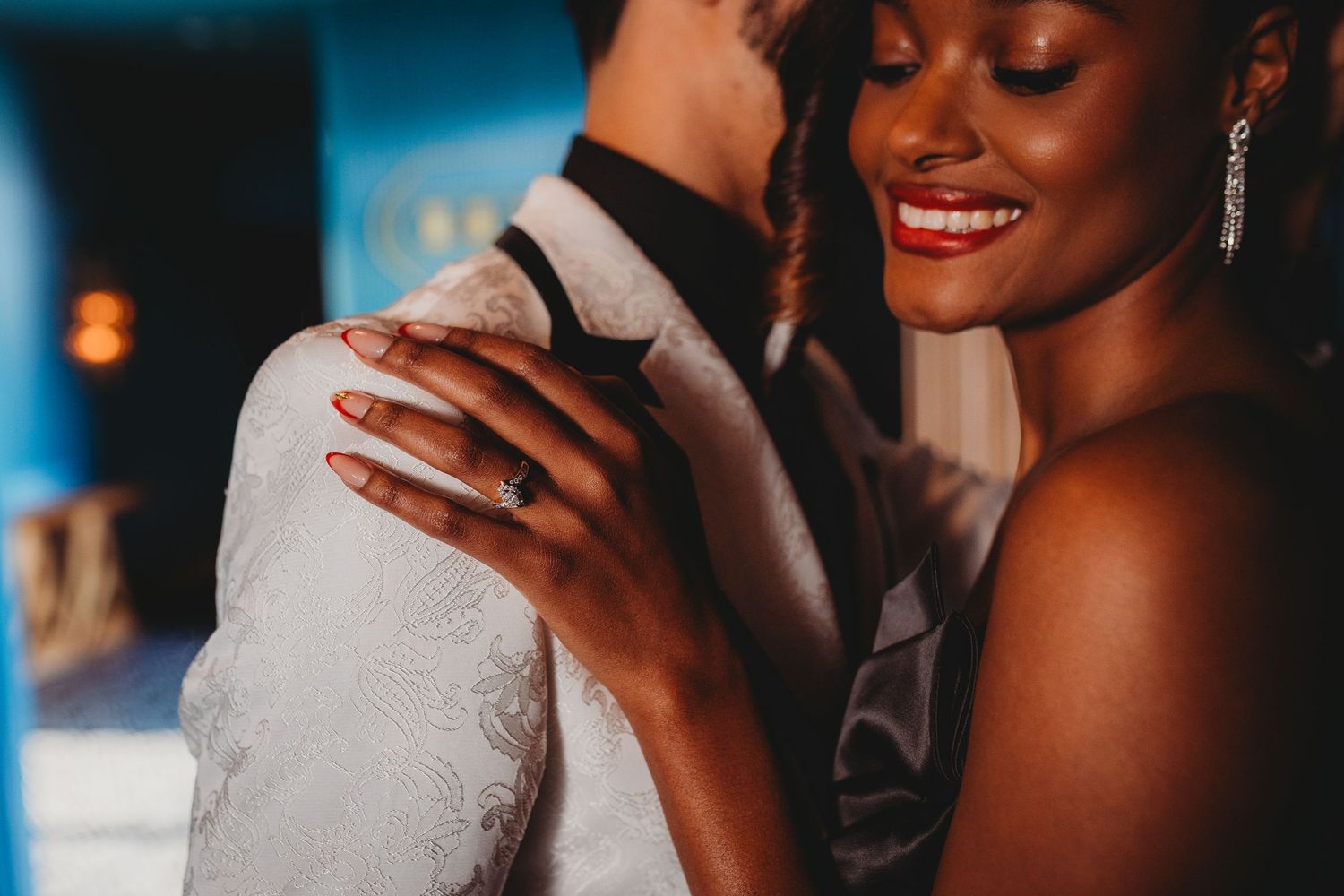 A couple shares an intimate dance moment at a wedding reception with soft lighting and warm ambiance.
