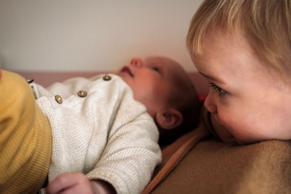 A series of tender moments between parent and baby showing gentle kisses and snuggles in warm lighting.