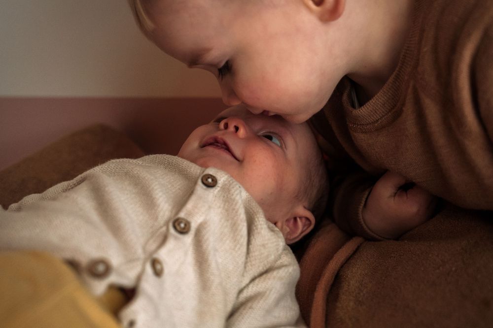 A series of intimate close-up shots showing tender moments between parent and child in warm lighting.