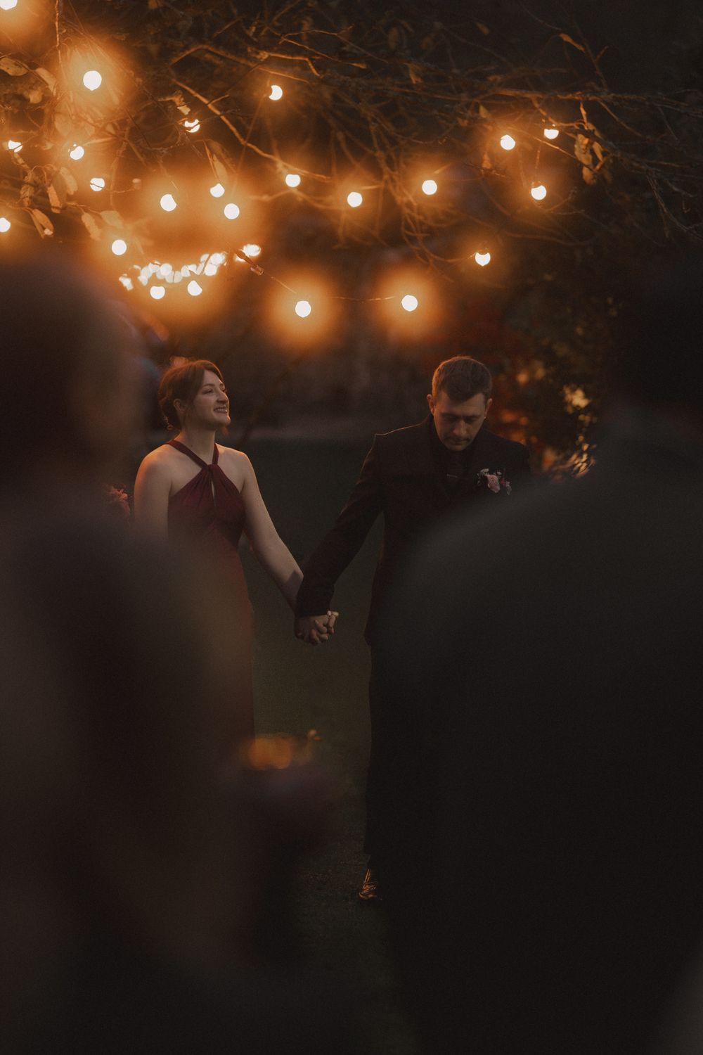 Romantic outdoor evening celebration with string lights illuminating the dark atmosphere.