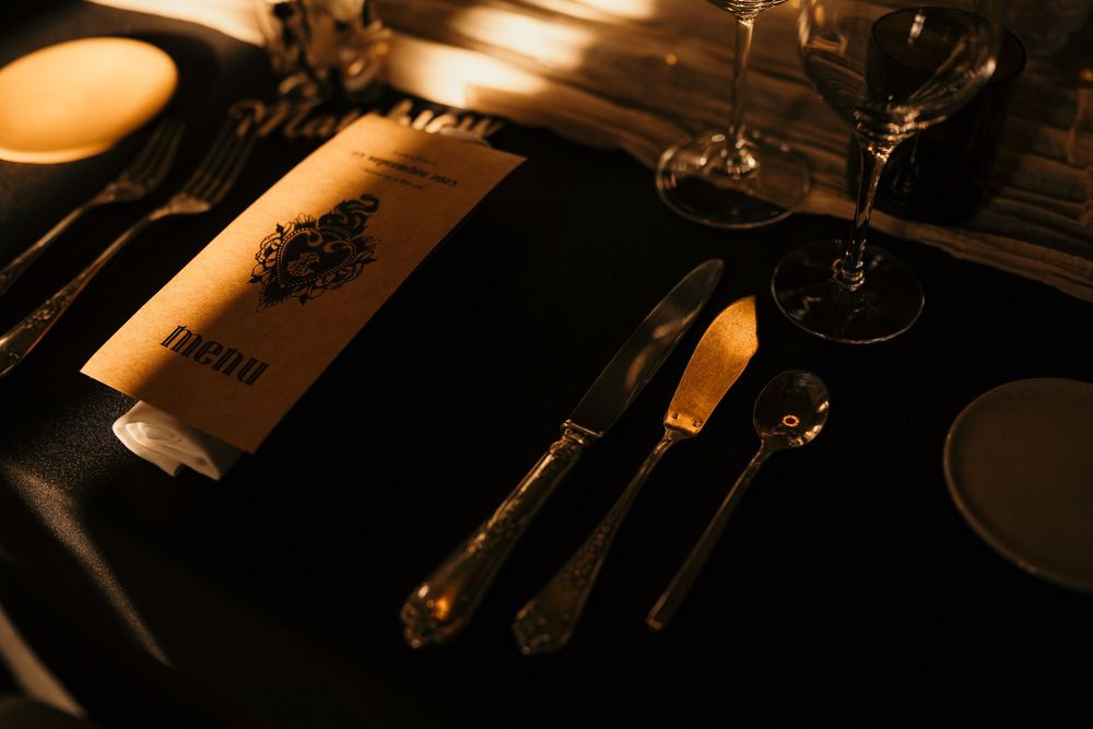 A row of wine glasses on a dark table with warm ambient lighting creating a sophisticated dining atmosphere.