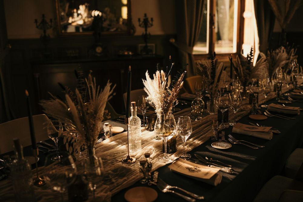Elegant table settings with candlelight and glassware in a dimly lit restaurant create a romantic dining atmosphere.