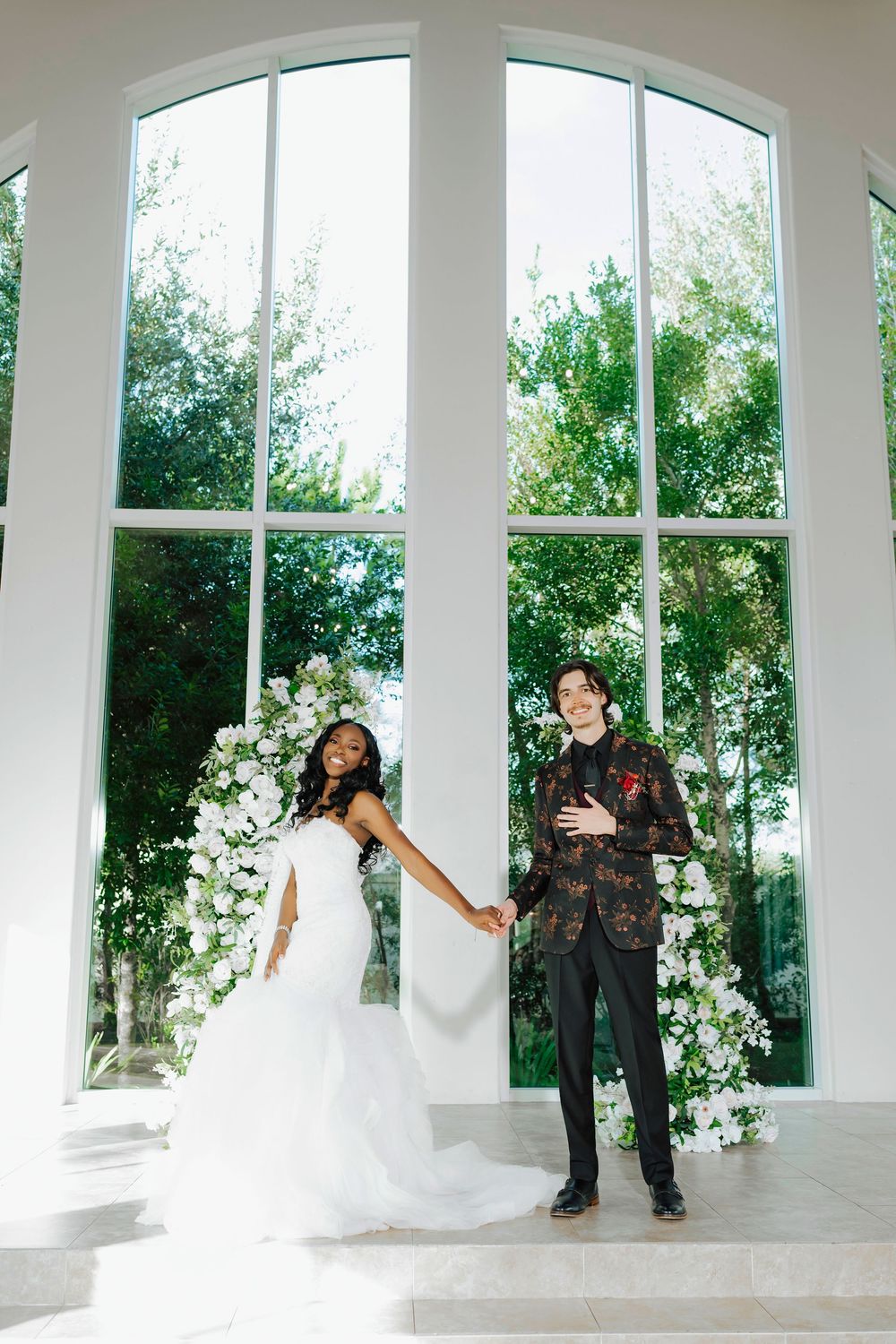 A series of four wedding photos showing a couple in an elegant white chapel with large arched windows and floral decorations.