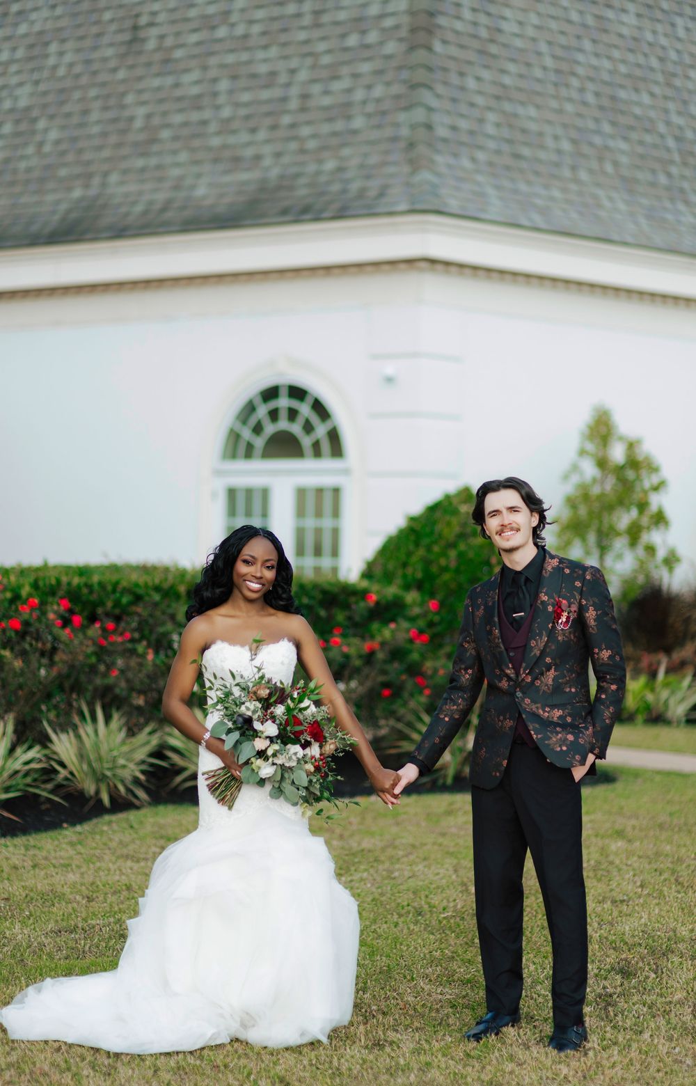 A wedding couple poses playfully on the grass in a series of candid photos outside a white church building.