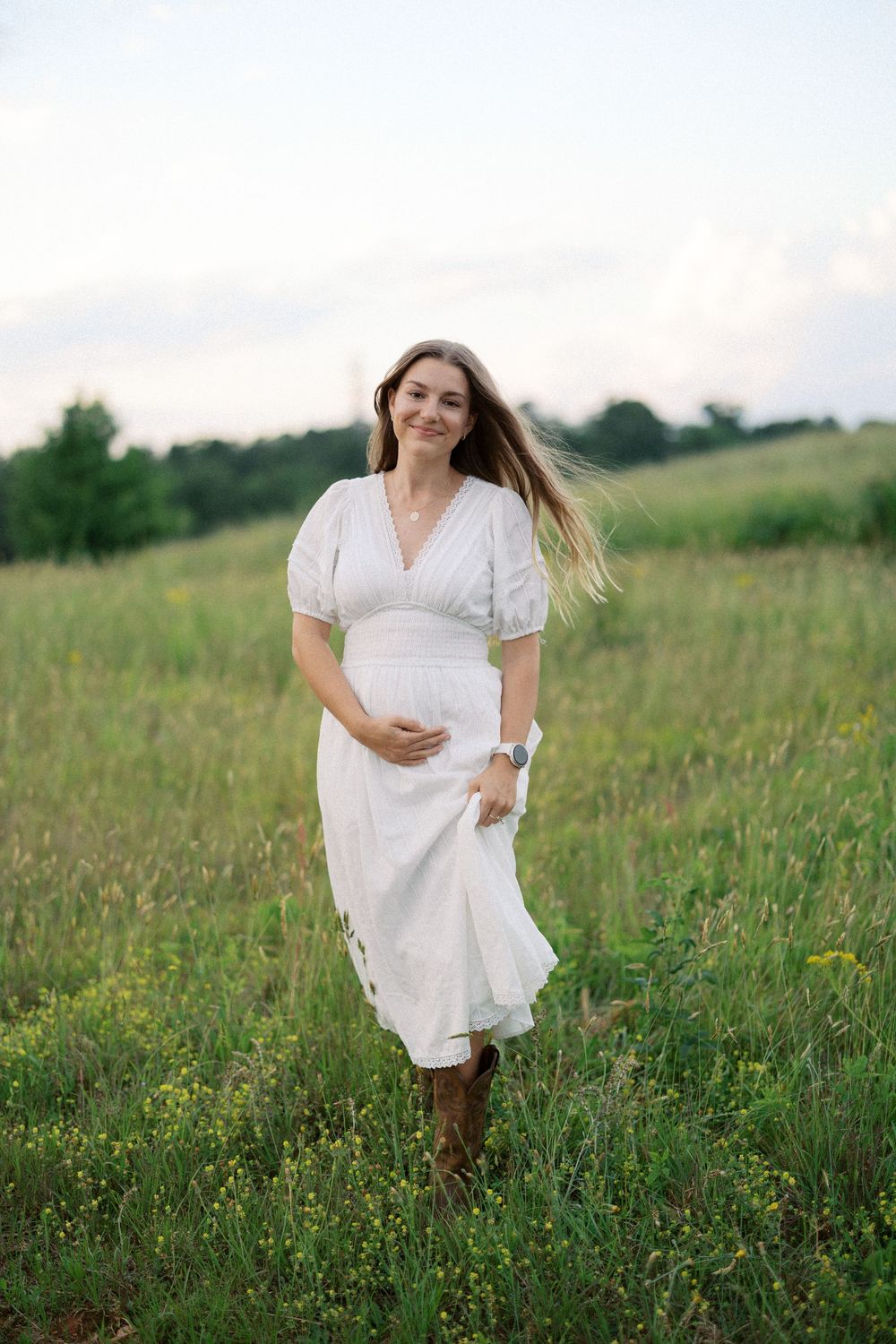 A person in a flowing white dress runs through a sunlit meadow filled with wildflowers on a summer afternoon.