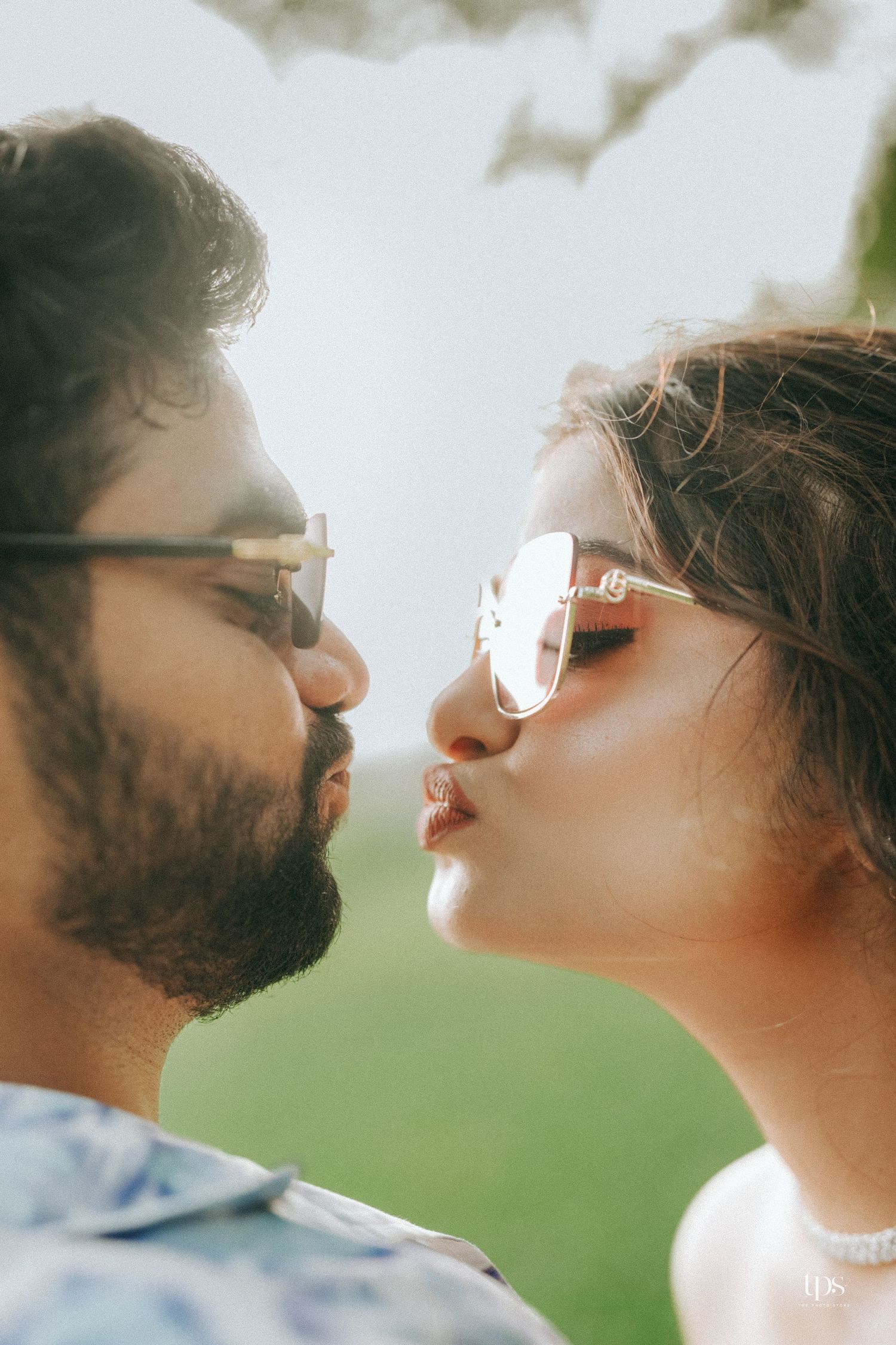 Close-up profile view of a couple in sunglasses about to kiss.
