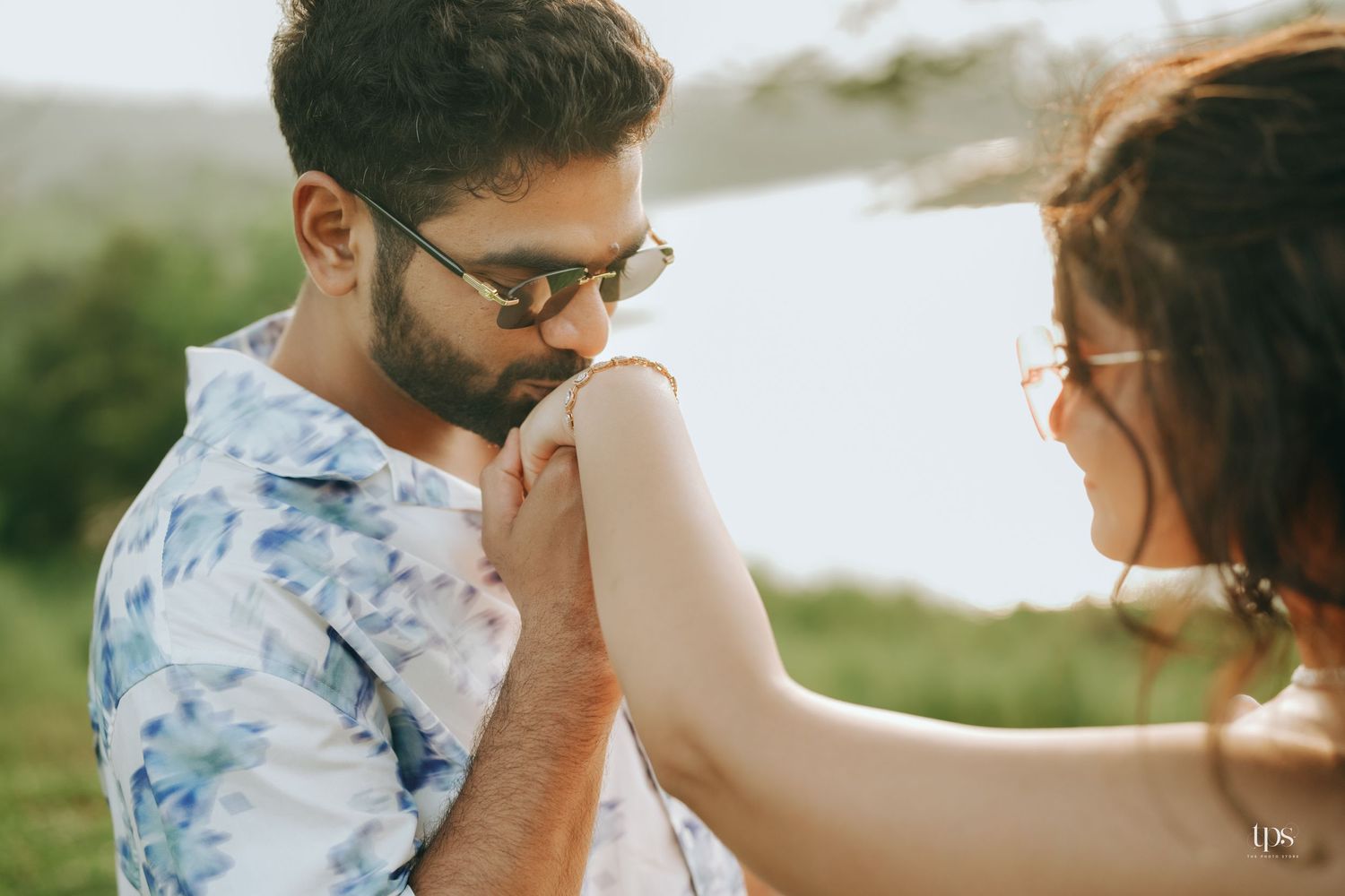 A couple holds hands while dancing in a natural outdoor setting.