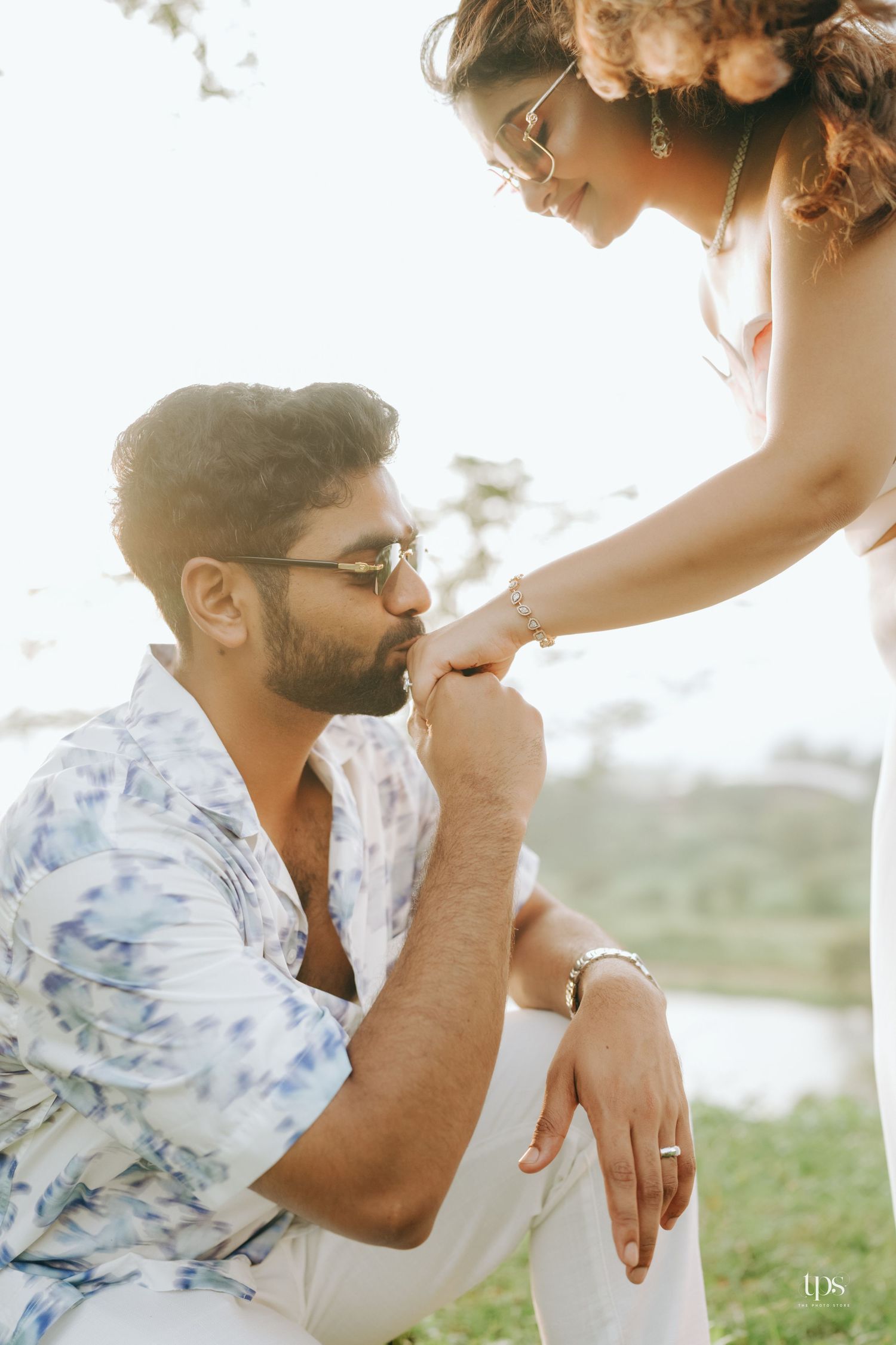 Sunlit outdoor portrait session showing tender romantic moments on grassy field.