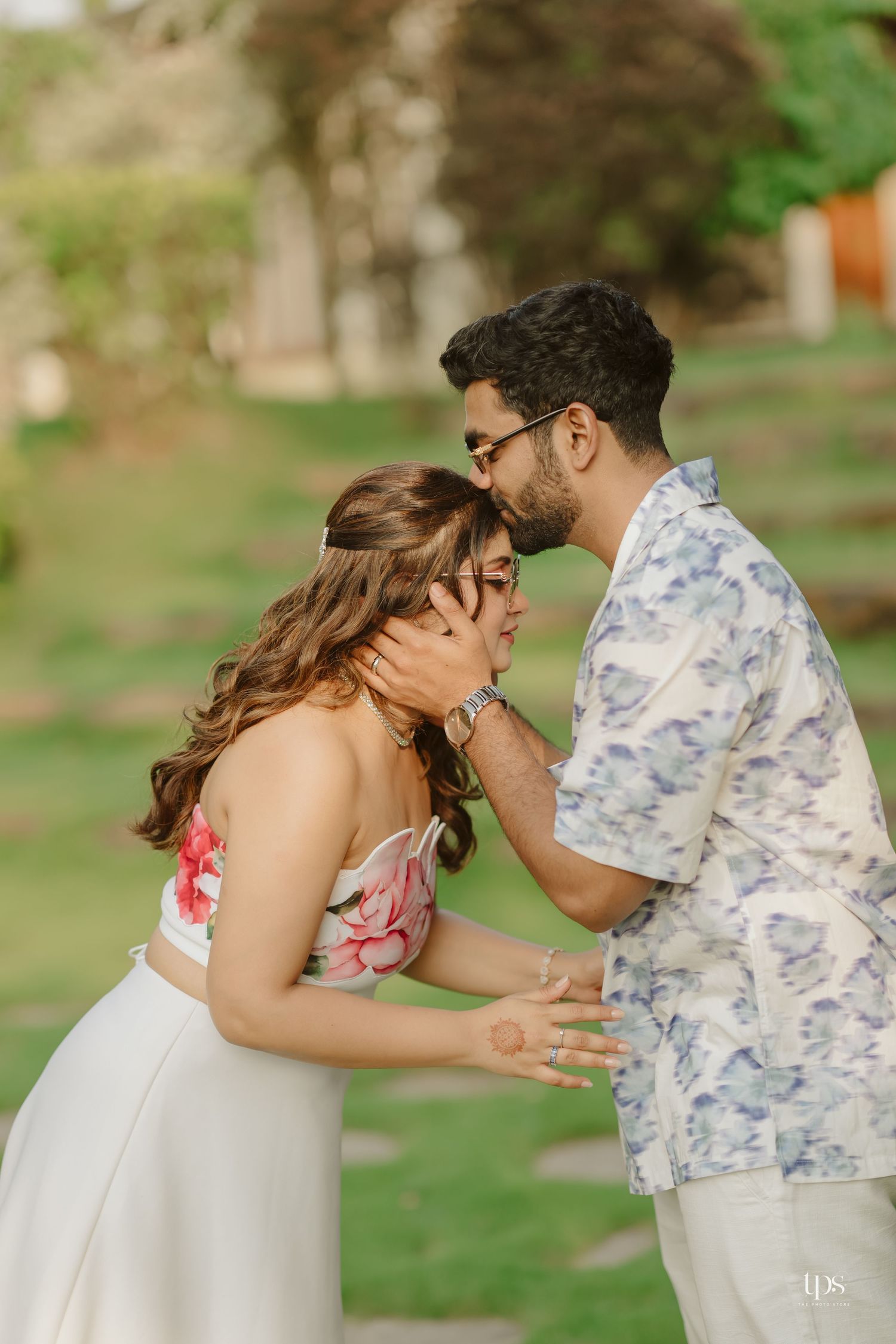A tender embrace captured in a garden setting during a romantic photoshoot.